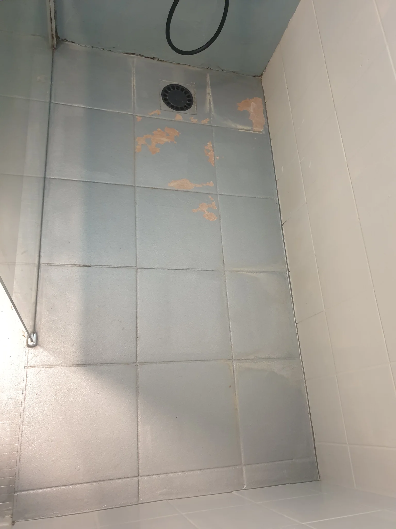 Ancien receveur de douche carrelé, joints abîmés et carrelage écaillé