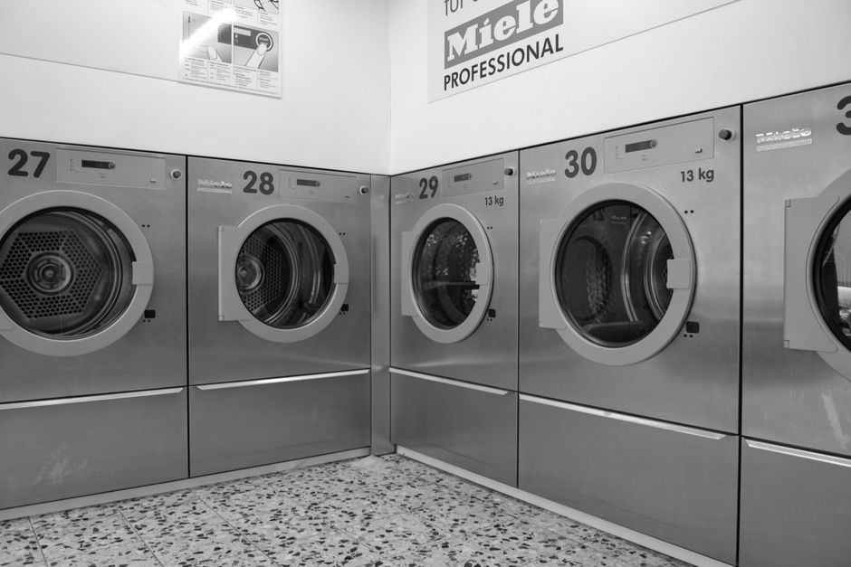 Rangée de lave-linge et sèche-linge professionnels dans une buanderie