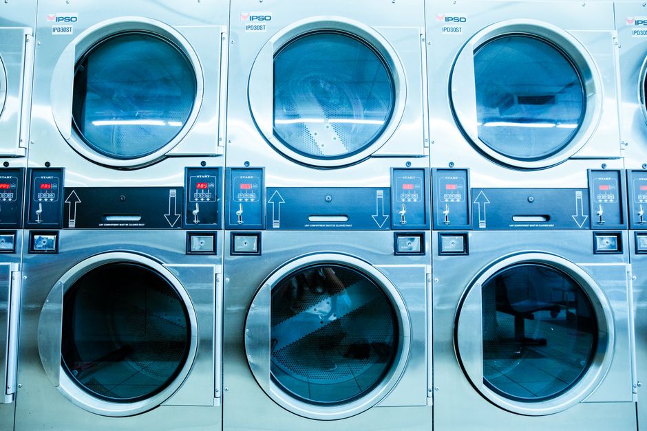 Hublots de sèche-linge alignés dans une laverie